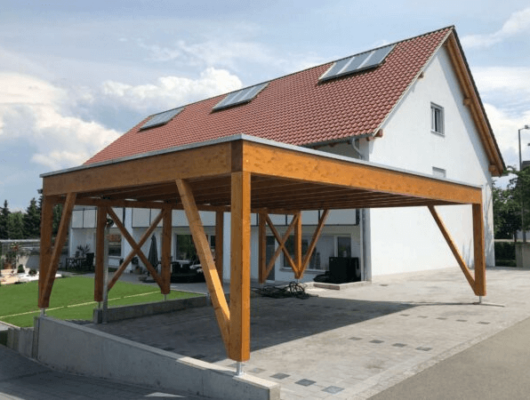 Ein umweltbewusstes Haus mit Carport und Solarpanelen auf dem Dach, ideal für nachhaltiges Wohnen.